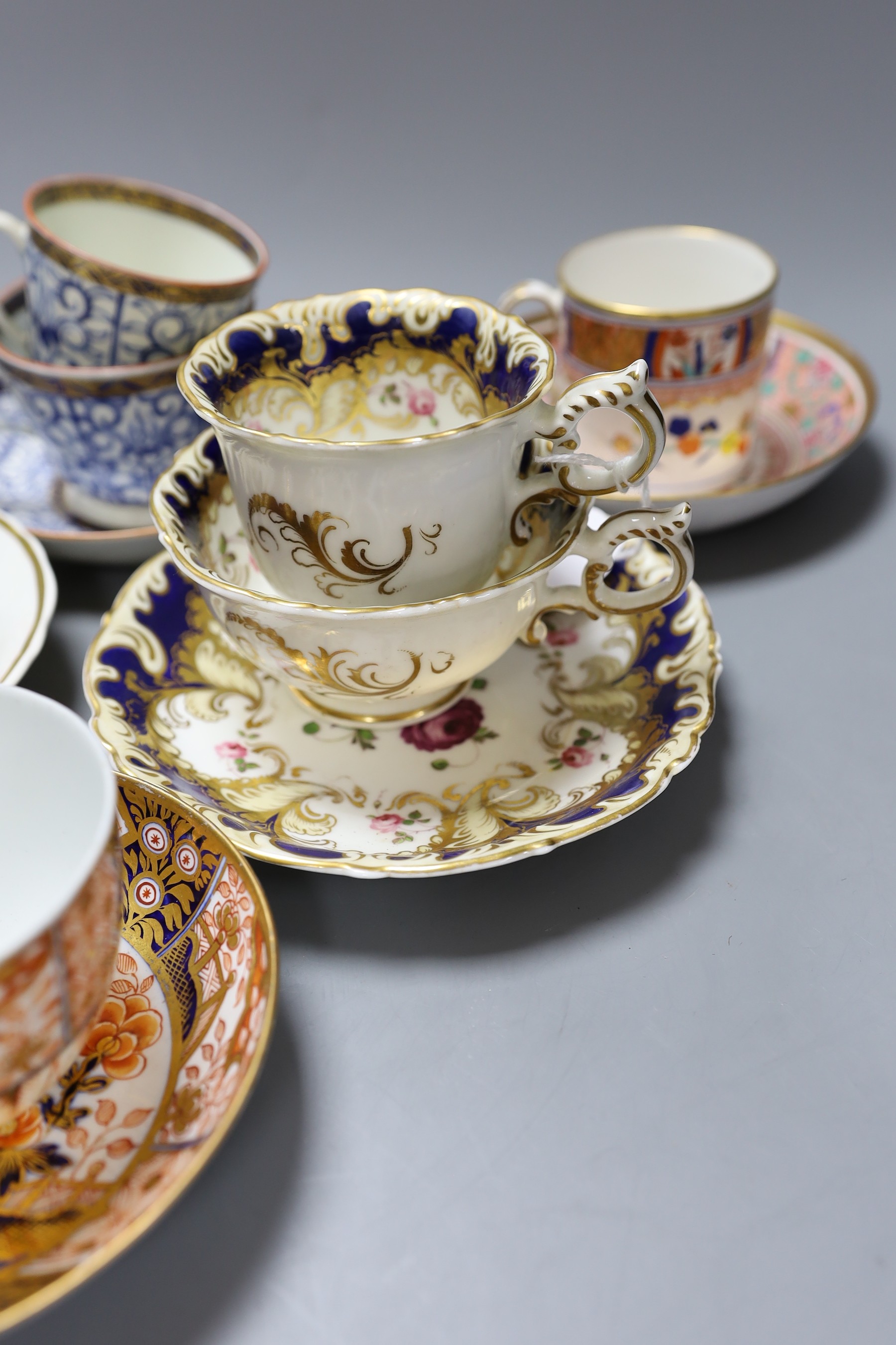 A Spode Imari pattern coffee can and saucer, a Coalport Imari cup and saucer, a Coalport style floral trio, a Worcester Royal Lily trio, a Flight teabowl and saucer and an English rose painted cup and saucer